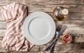 Vintage Table setting with napkin, fork, knife and plate on old rustic wooden table Royalty Free Stock Photo