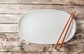 Vintage Table setting with oval plate and chopsticks on old rustic wooden table Royalty Free Stock Photo