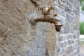 vintage tap with running water on outside wall. outdoor garden faucet on yard background Royalty Free Stock Photo