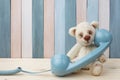 Vintage Teddy Bear with retro telephone on wooden background Royalty Free Stock Photo