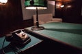 Vintage telephone and reading lamp on a table with green cloth