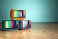 Vintage television concept. Stack of retro tv set on green background.