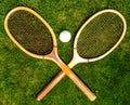 Vintage tennis racquets with traditional white ball on grass court Royalty Free Stock Photo