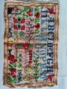 Vintage textile needle work. Old fabric with embroidered letters and flowers.