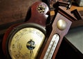 Vintage thermometer and barometer laying in a wooden chest