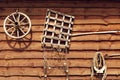 vintage things: a wooden wagon wheel, a harrow, a fishing net, a yoke, a hoe hanging on a wooden barn wall Royalty Free Stock Photo