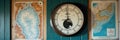 Vintage tidemaster tide clock between nautical maps on blue wall Royalty Free Stock Photo