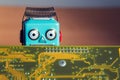 Vintage tin toy robot behind computer board, artificial intelligence concept Royalty Free Stock Photo