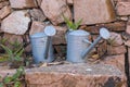 Vintage Tin Watering Can near a Wall Made of Red Stones Royalty Free Stock Photo