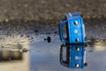 Vintage tinwork toy car with Volkswagen logo in puddle in front of dealership on March 23, 2016 in Prague, Czech republic