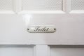 Vintage toilet sign with the words toilet on a white wooden door