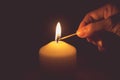 Vintage tone of hand with matchstick, lighting a candle