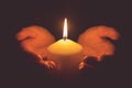 Vintage tone of hands holding a burning candle in dark