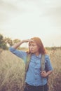 Vintage tone images of beautiful young hipster woman with backpack walking on meadow. Portrait of hiker girl outdoor. Royalty Free Stock Photo