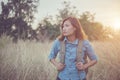 Vintage tone images of beautiful young hipster woman with backpack walking on meadow. Portrait of hiker girl outdoor. Royalty Free Stock Photo