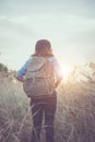 Vintage tone images of beautiful young hipster woman with backpack walking on meadow. Portrait of hiker girl outdoor. Royalty Free Stock Photo