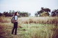 Vintage tone images of beautiful young hipster woman with backpack walking on meadow. Portrait of hiker girl outdoor. Royalty Free Stock Photo