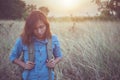 Vintage tone images of beautiful young hipster woman with backpack walking on meadow. Portrait of hiker girl outdoor. Royalty Free Stock Photo