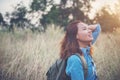 Vintage tone images of beautiful young hipster woman with backpack walking on meadow. Portrait of hiker girl outdoor. Royalty Free Stock Photo