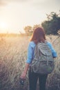 Vintage tone images of beautiful young hipster woman with backpack walking on meadow. Portrait of hiker girl outdoor. Royalty Free Stock Photo