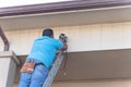 Rear view of technician installing surveillance camera on roof