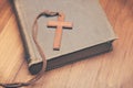 Vintage tone of wooden Christian cross necklace on holy Bible Royalty Free Stock Photo