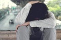 Vintage toned image of anxious frustrated young Asian business man sitting and touching forehead with hands.