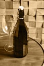 Vintage toned image of a bottle with wine and a wine glass on a wooden table