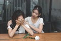 Vintage toned image of frustrated stressed Asian woman comforting a sad depressed female friend. Break up or best relationship con