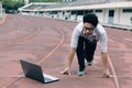 Vintage toned image of young Asian businessman with laptop ready start position to forward on race track. Competition and vision b Royalty Free Stock Photo