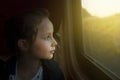 Vintage toned mage of Little Girl looking through window. She travels on a railway train. Copy space.