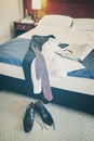 Vintage toned male black shoes and clothes on a hotel room bed Royalty Free Stock Photo