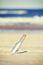 Vintage toned message in a bottle on beach, shallow depth of fie Royalty Free Stock Photo