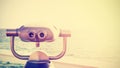 Vintage toned photo of a binocular pointed at horizon.