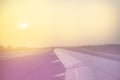 Vintage toned plane wing above runway at sunrise Royalty Free Stock Photo