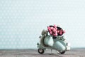 Vintage toy blue motorcycle with bunch of pink flowers Royalty Free Stock Photo