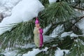 Vintage toy Christmas tree on a pine branch. A glass statuette of a clown of Parsley. Old hand glass Christmas ornament on a livin