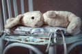 Vintage toy rabbit.Old vintage soft toy hare lying in vintage white chair