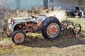 Vintage tractor and implement in front of barn