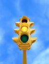 Vintage traffic light with yellow light on blue sky background Royalty Free Stock Photo