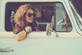 Vintage travel style image concept lifestyle. One cheerful happy woman enjoy destination sitting inside her blue classic van