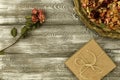 Vintage tray with petals of dried rose flowers, gift box wrapped in kraft paper on a gray table. Flat styling. Copy space for text Royalty Free Stock Photo