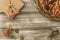 Vintage tray with petals of dried rose flowers, gift box wrapped in kraft paper on a gray table. Flat styling. Copy space for text Royalty Free Stock Photo