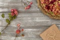 Vintage tray with petals of dried rose flowers, gift box wrapped in kraft paper on a gray table. Flat styling. Copy Royalty Free Stock Photo