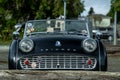 Vintage Triumph Spitfire car parked behind a log