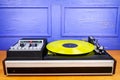 Vintage turntable vinyl record player with yellow vinyl Royalty Free Stock Photo