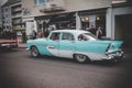 Vintage turquoise car during a cruising event on a city road