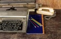 Vintage typewriter ,blue book, ,pencil and old telephone on ol Royalty Free Stock Photo