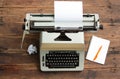 Vintage typewriter with the Cyrillic alphabet and a sheet of paper on an old table, a notebook and a pen Royalty Free Stock Photo