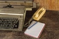 Vintage typewriter ,white  book,  ,pencil and old telephone on old wooden touch-up in still life concept Royalty Free Stock Photo